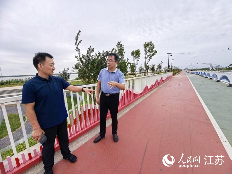朱新昌(左一)与海门区水利局副局长郁杰弓实地调研江堤路。人民网记者 王继亮摄