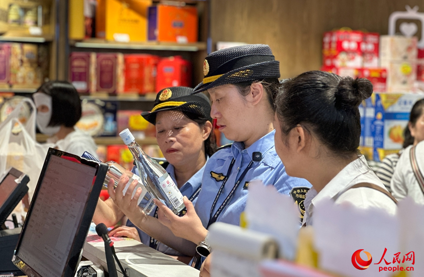 国庆假期，许昌市市场监督管理局魏都区分局执法人员在商超开展食品安全检查。人民网记者 宋芳鑫摄