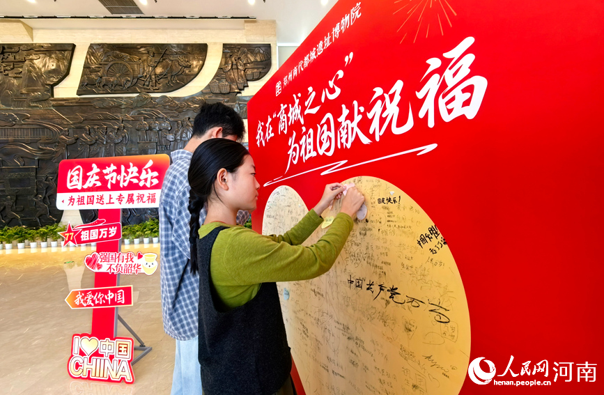 国庆假期,游客打卡郑州商都遗址博物院,在表白墙上写下对祖国的祝福。人民网记者 宋芳鑫摄