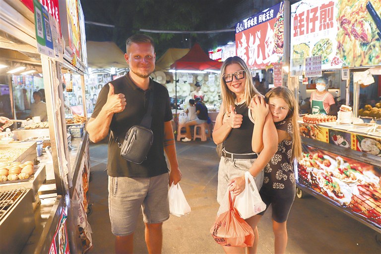 在三亚红旗街夜市，游客选购特色海鲜小吃。海南日报全媒体记者 王程龙 摄